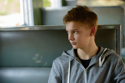 Portrait of teenage boy looking away at home