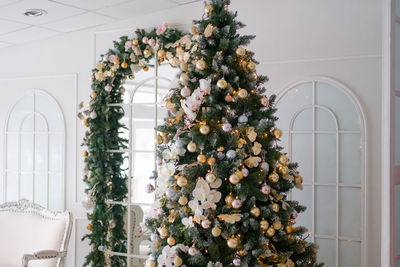 Luxurious christmas interior in light colors. decorated christmas tall tree in a bright room