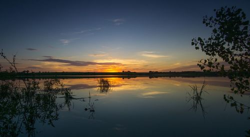 Scenic view of calm lake at sunset