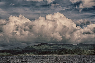 Scenic view of sea and mountains against sky