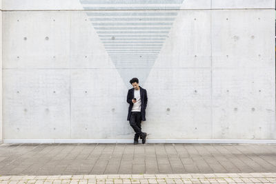 Full length of man standing on concrete wall