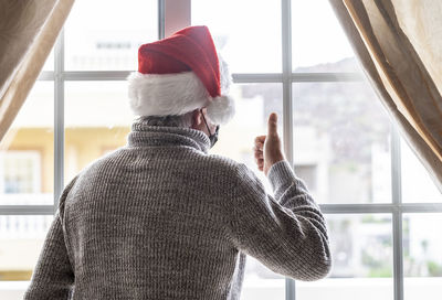 Rear view of man in hat seen through window