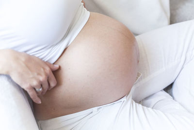 Midsection of woman lying on bed