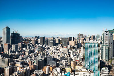 Modern buildings in city against blue sky