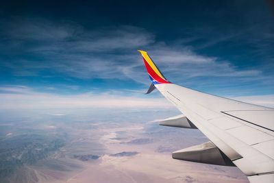 Airplane flying over clouds against sky