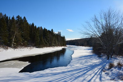 Scenic view of snow covered landscape against clear blue sky