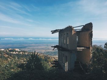 Abandoned building by sea against sky