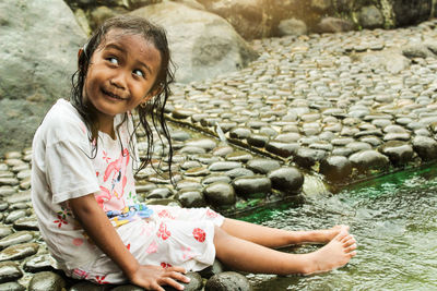 Portrait of smiling girl on rock