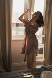 Rear view of woman standing against wall