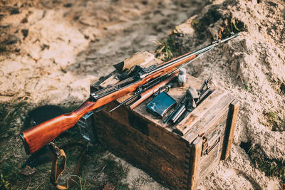 High angle view of gun on wooden box outdoors