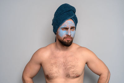 Portrait of shirtless man against white background