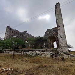 Old ruin on field against sky