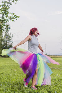 Woman dancing on field against trees