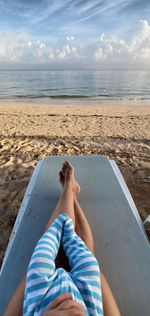 Top view of mother and baby legs on a beach chair by the water