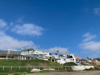 Buildings near beach against blue sky