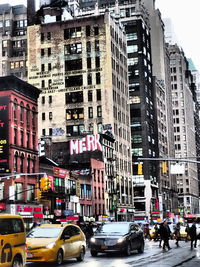 Traffic on road by buildings in city