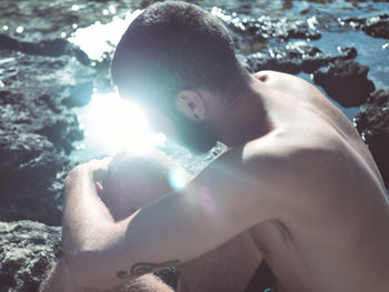 Close-up of shirtless man swimming in sea