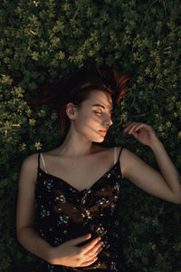 Beautiful young woman standing against plants