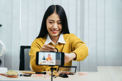 Portrait of a smiling young woman using smart phone