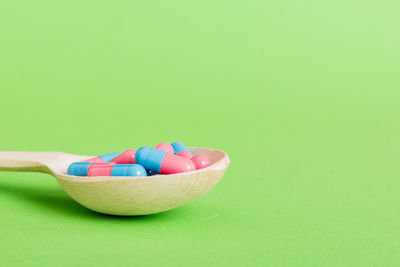 High angle view of pills in bowl on yellow background