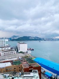 High angle view of buildings by sea against sky