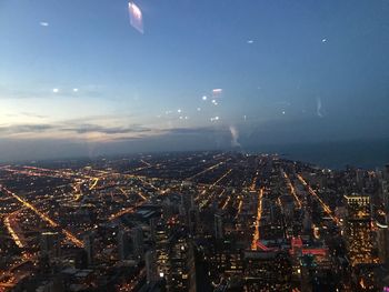 High angle view of illuminated city against sky at night