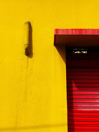 Low angle view of closed door on yellow wall