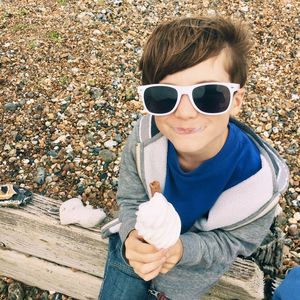 Portrait of a boy wearing sunglasses eating an ice cream outdoors