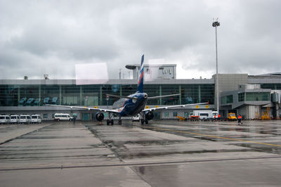 Airplane on airport runway against sky