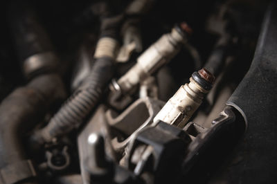 Old dirty injectors on the fuel rail in selective focus