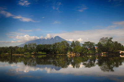 Scenic view of lake by trees against sky