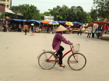 Side view of woman riding bicycle on street