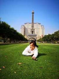 Full length of smiling woman on grass against sky