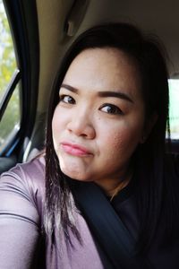 Close-up of smiling woman looking away while traveling in car