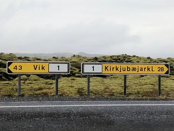 Information sign on road against sky