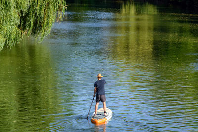 Rear view of man standing in lake