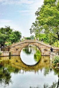 Arch bridge over water against sky