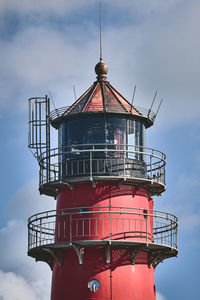 Lighthouse by sea against sky