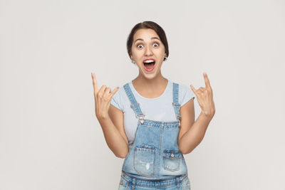 Portrait of young woman standing against white background