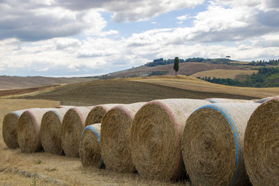 Hay bales on field against sky