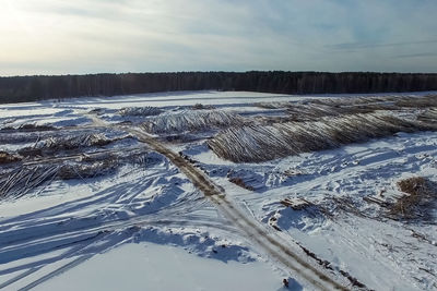 Scenic view of snow covered land against sky