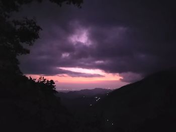 Scenic view of silhouette mountains against dramatic sky