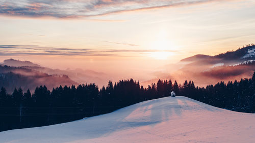 Scenic view of snow covered landscape against sky during sunset