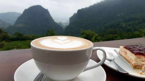 Close-up of coffee on table against mountains