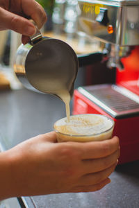 Cropped hands making coffee at table