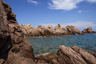 Scenic view of rocks in sea against sky