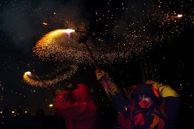 People holding firework at night