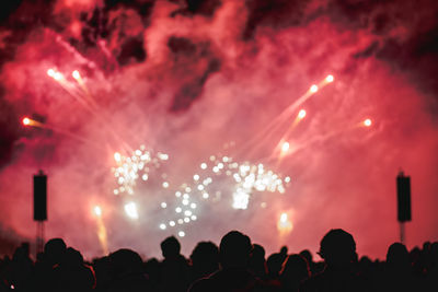 Crowd at music concert against sky at night