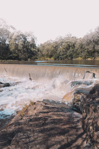 Scenic view of waterfall against clear sky