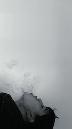 Portrait of man smoking against sky